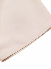 Apricot midi dress with V-neck and pleated detail, showing fabric texture.