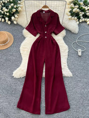 Burgundy belted wide-leg maternity jumpsuit with button front and short sleeves.