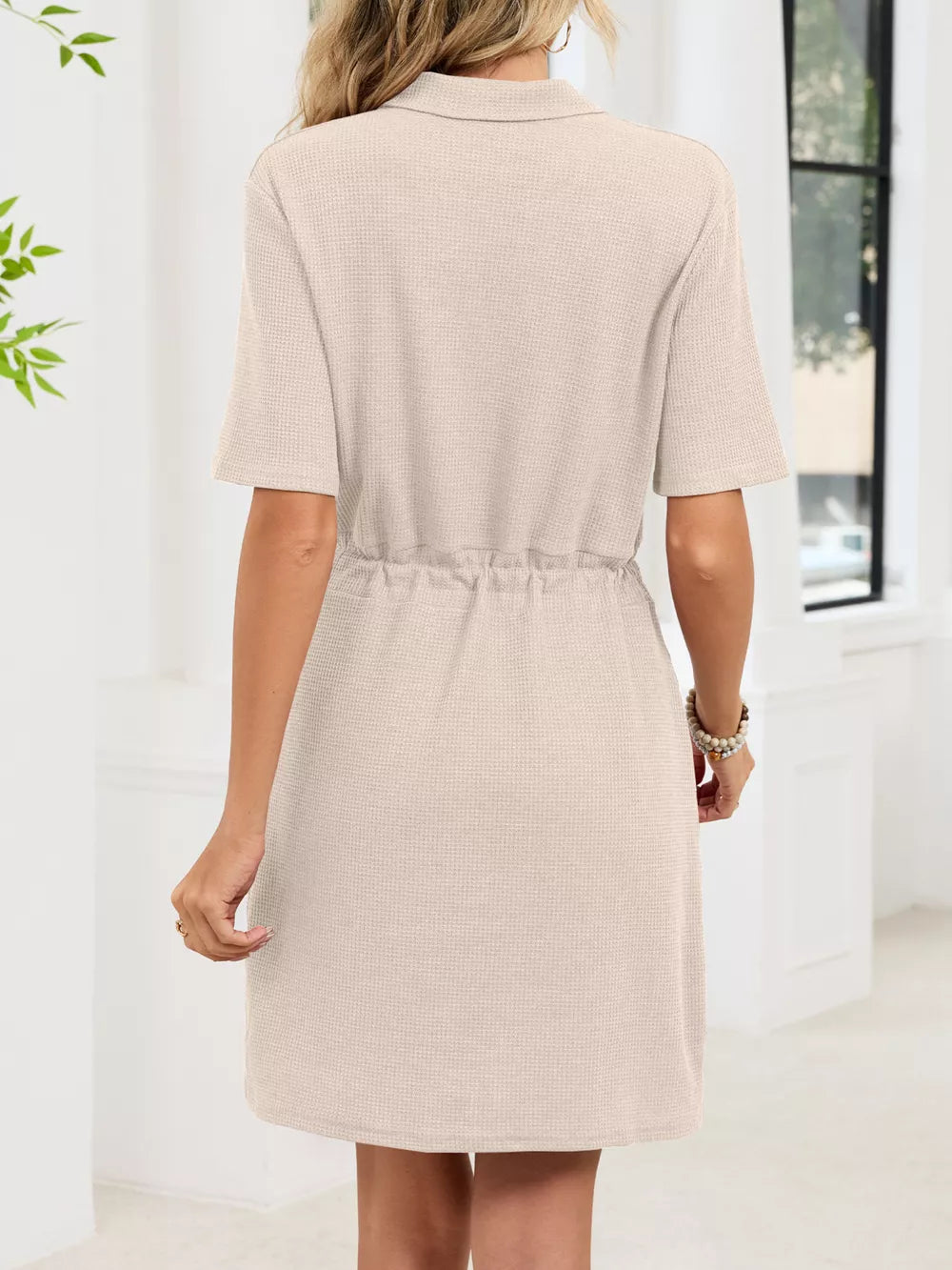 Textured polo dress in apricot with short sleeves and adjustable drawstring waist.
