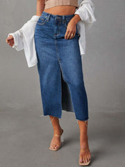 Medium wash denim midi skirt with raw hem and front slit.