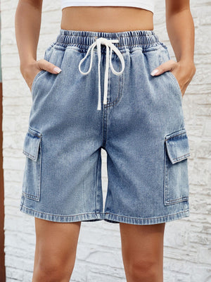 Denim cargo shorts in dusty blue with drawstring waist and side pockets.