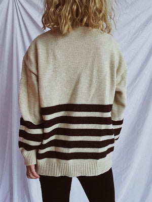 Horizontal stripe ribbed knit sweater in tan with dark gray stripes, crew neck, long sleeves.