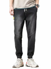 Men's relaxed fit black drawstring jeans with elastic cuffs and a distressed wash.