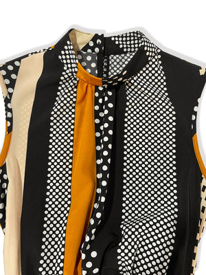 Black belted romper with polka dot and stripe print, mock neck detail.
