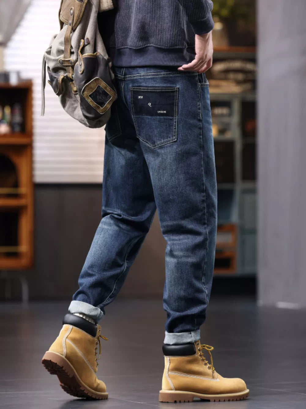 Men's relaxed fit blue denim jeans with a drawstring waist and cuffed hems.