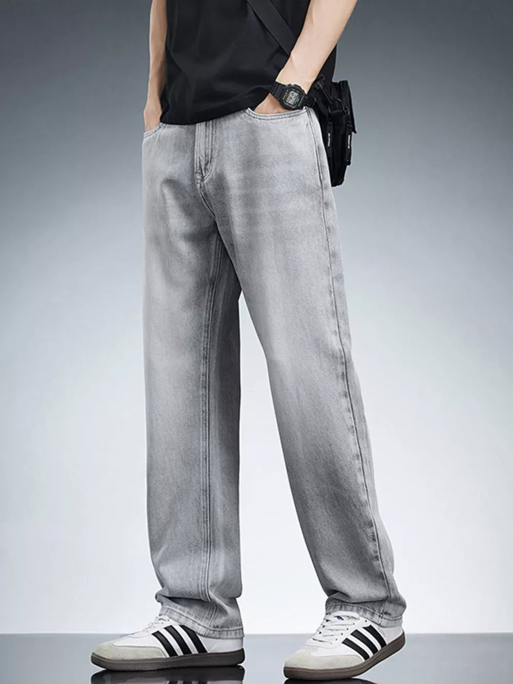 Men's light grey relaxed fit wide leg jeans in cotton, styled casually.