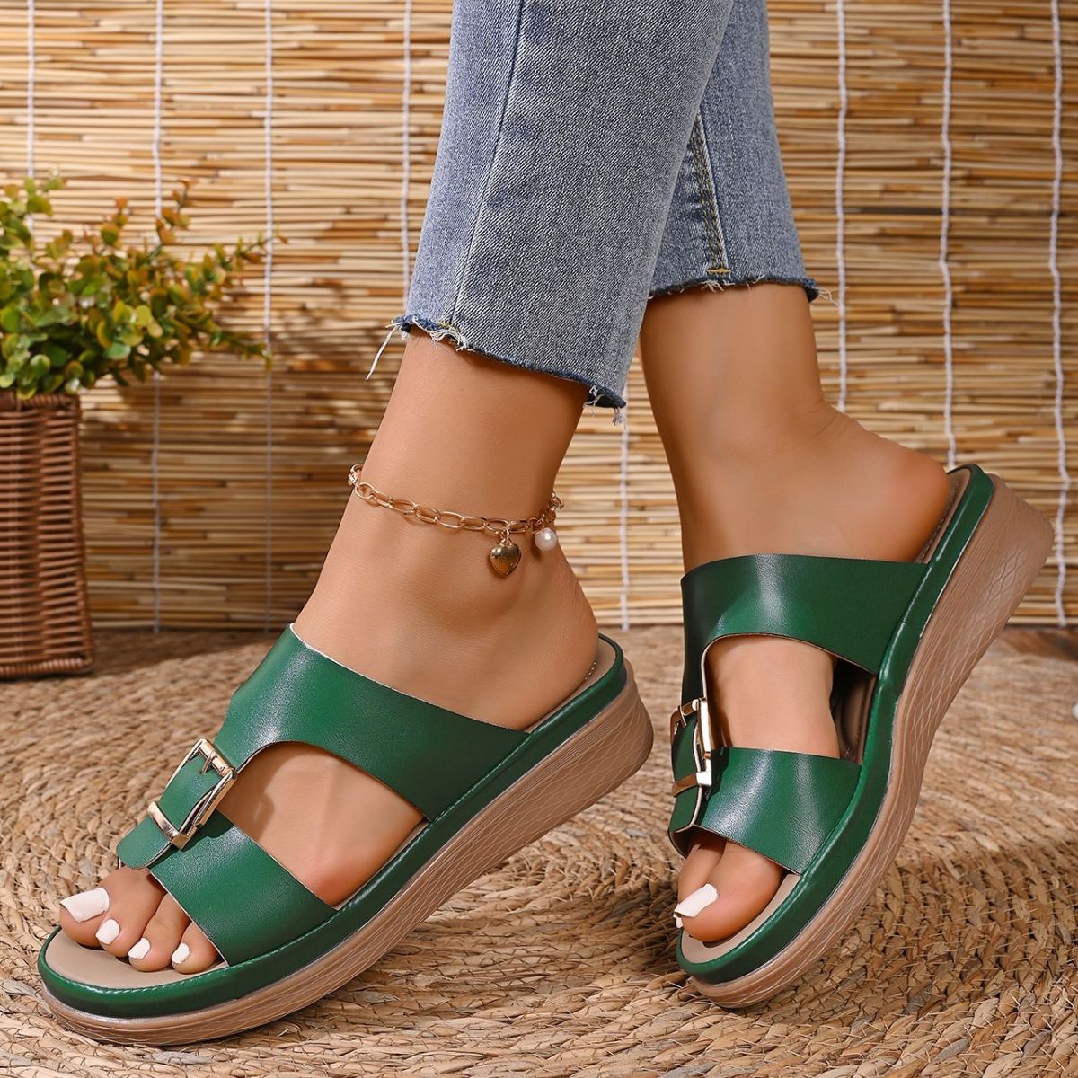 Green open-toe buckle sandals with a wedge heel and decorative buckle detail.