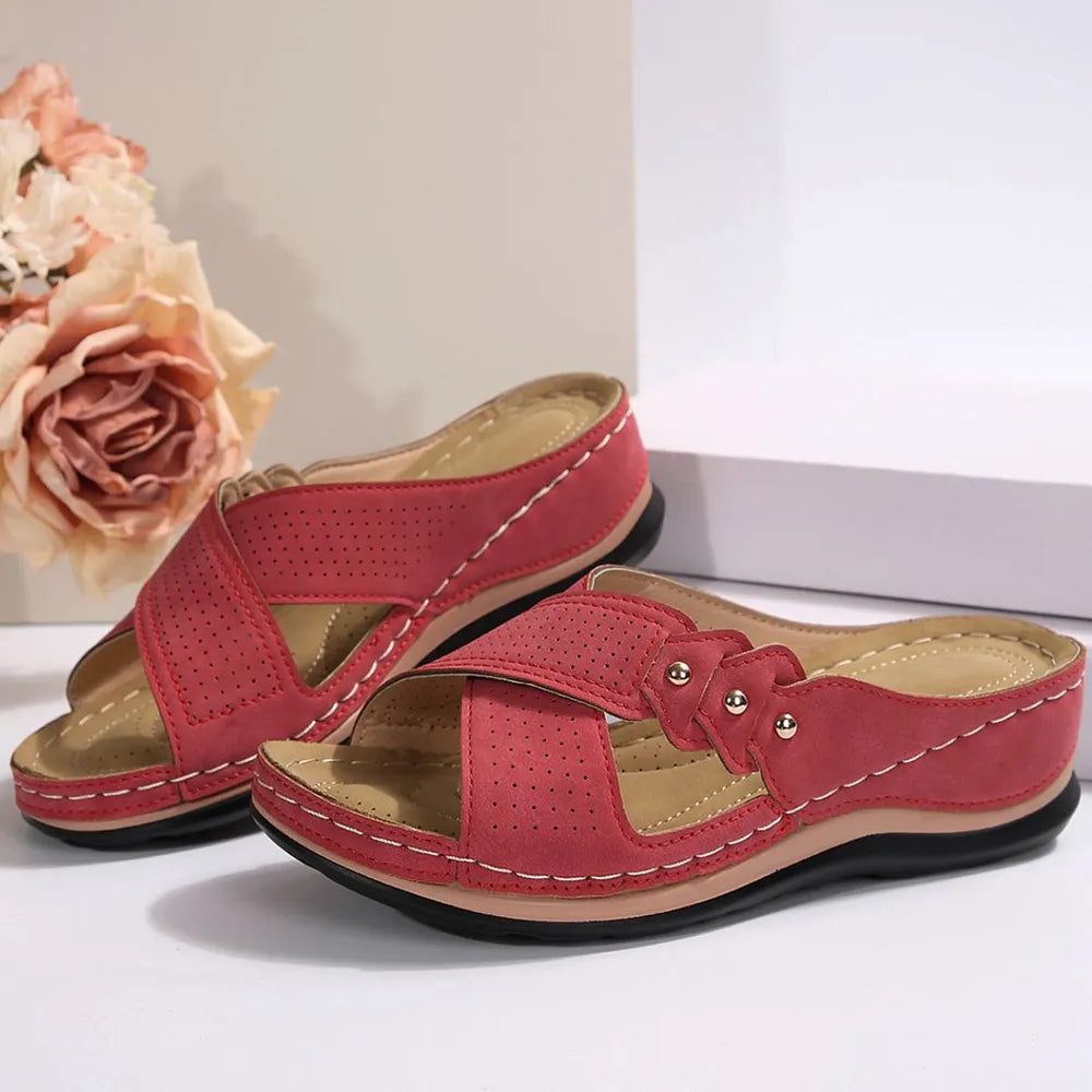 Red perforated cross-strap comfort sandals with white stitching detail.