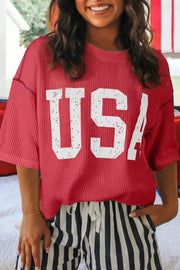 Red ribbed crew neck t-shirt with distressed white USA graphic and short sleeves.