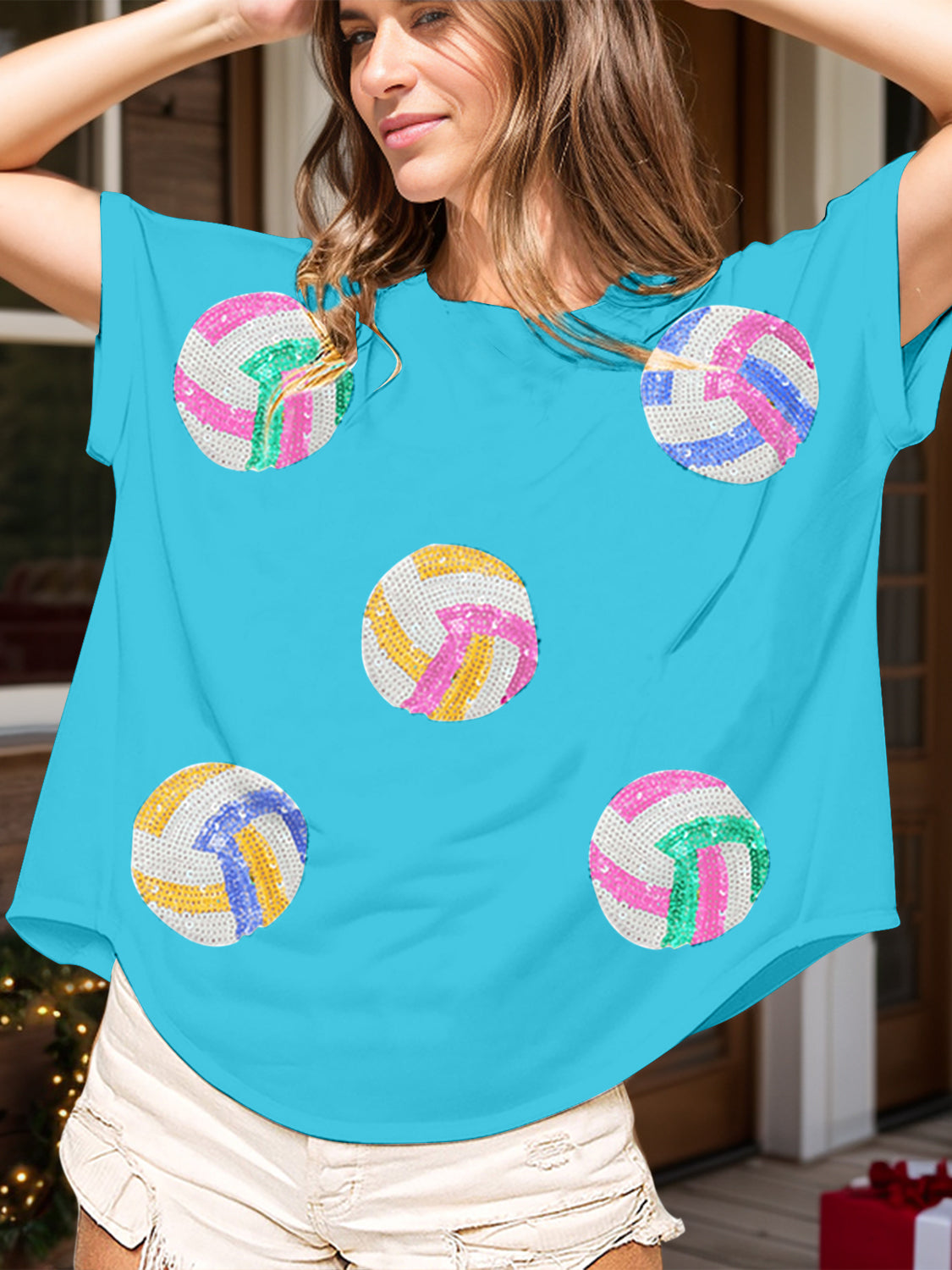 Sky blue t-shirt with sequin volleyball graphics in pink, green, yellow, and blue.