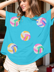 Sky blue t-shirt with sequin volleyball graphics in pink, green, yellow, and blue.