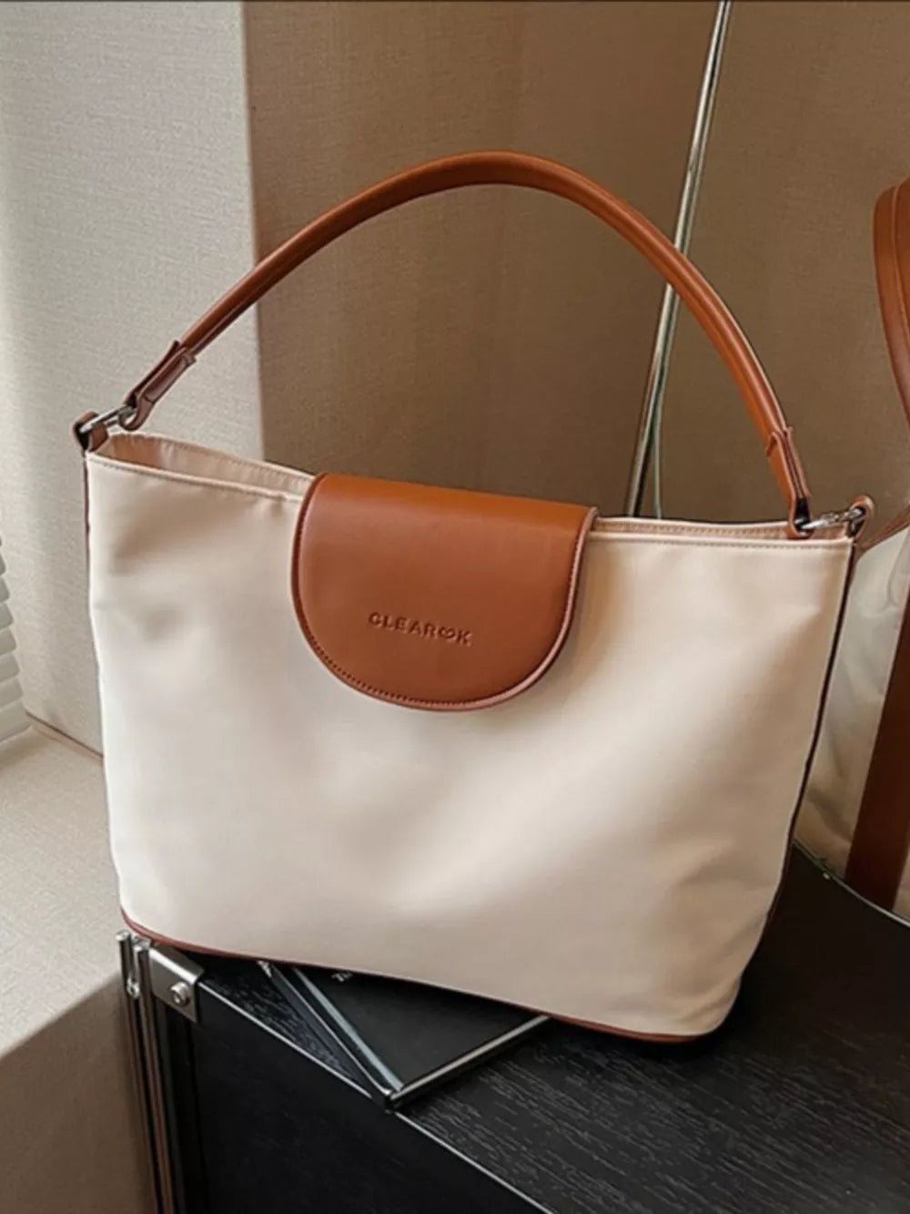 Chic canvas hobo crossbody bag in ivory with brown trim and strap.