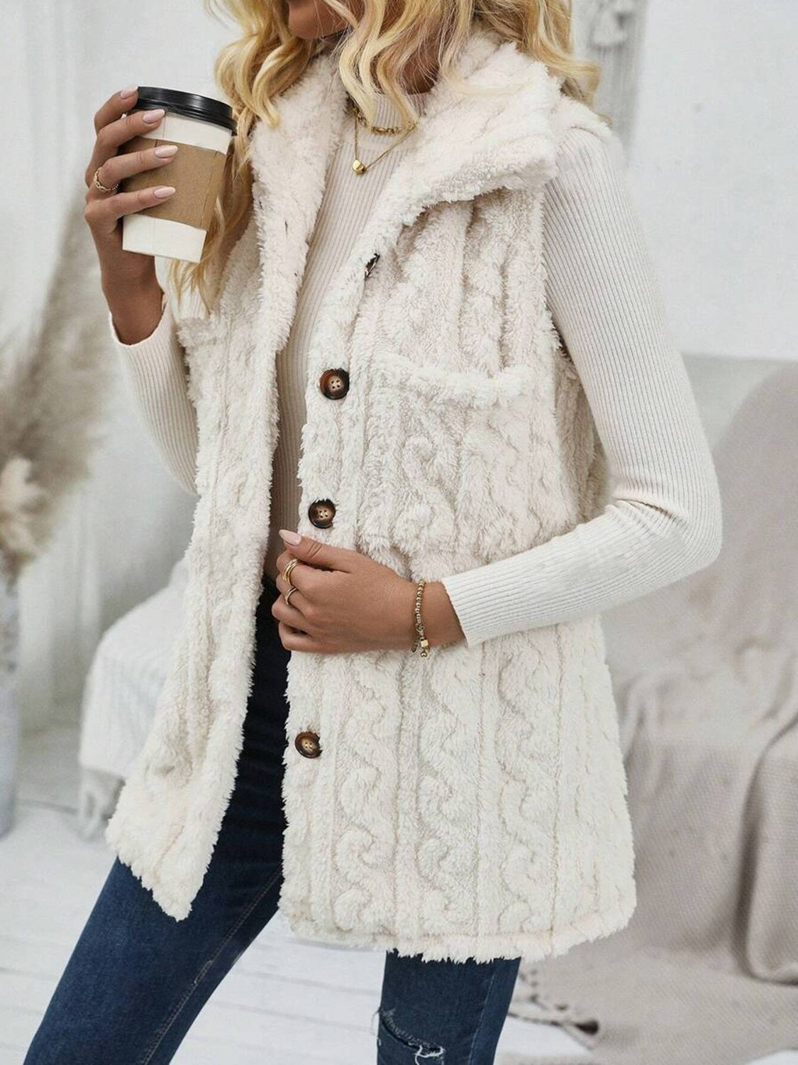 Textured sherpa button-down vest in beige with cable knit pattern and two front pockets.