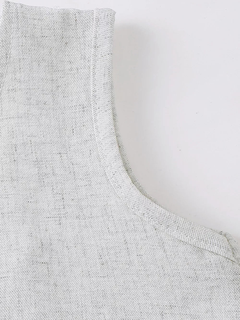 Baby vest detail in light grey textured fabric with clean stitching.
