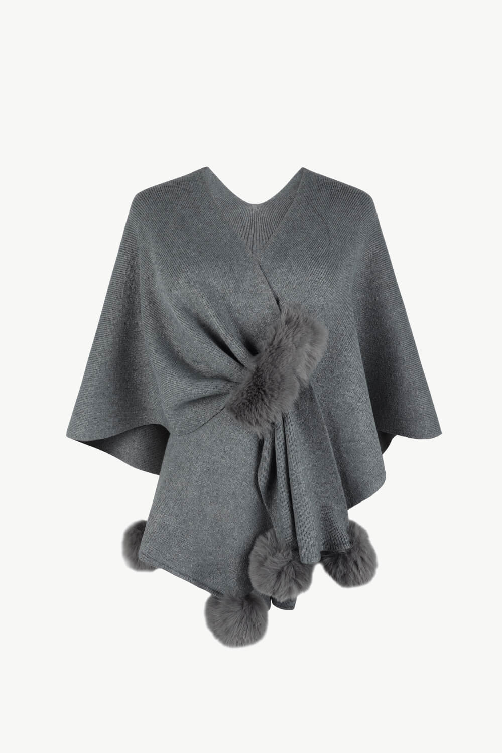 Charcoal knit cape with fur trim and pom-poms.