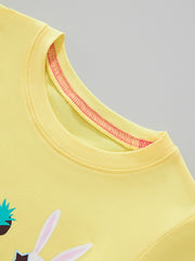 Yellow crew neck t-shirt with pink stitching detail and partial view of animal face graphic.