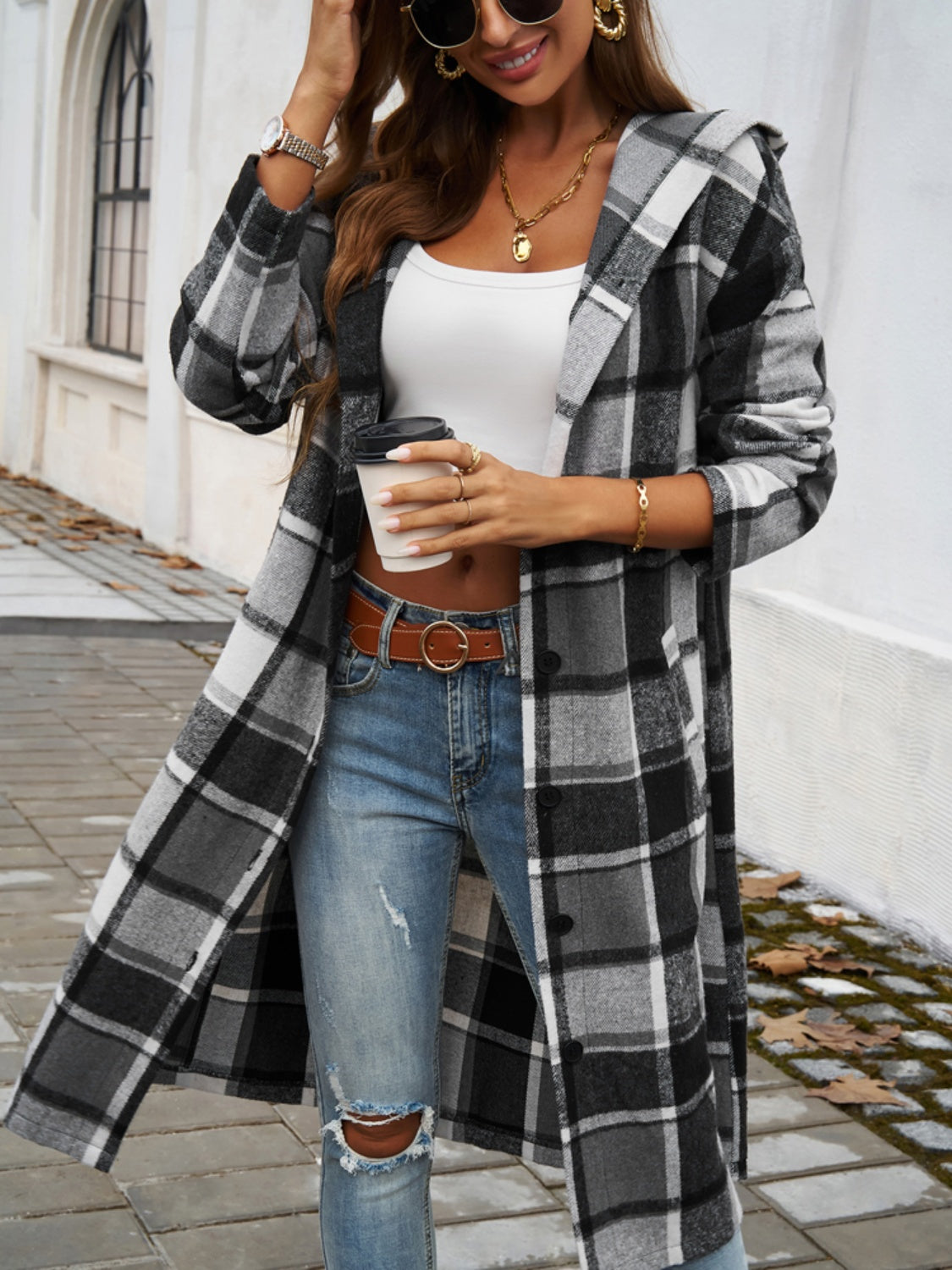 Checked plaid hooded duster coat in black and white, open front, buttoned detail.