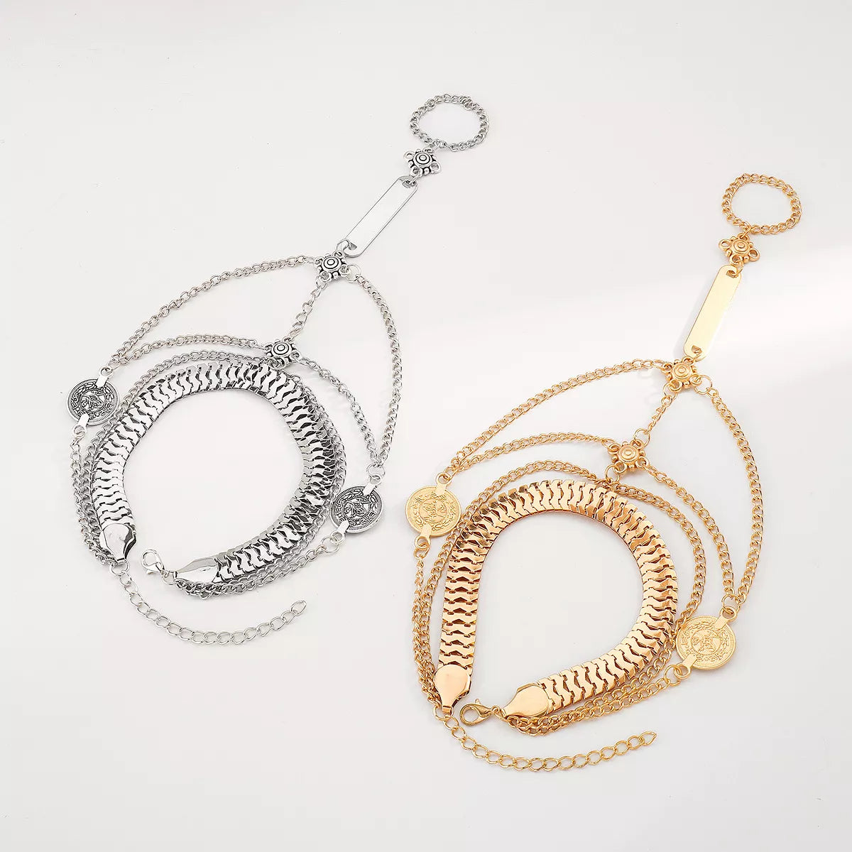 Chic multi-layered chain bracelet in gold and silver with coin charms.