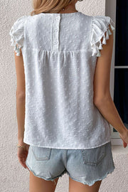 White dotted swiss blouse with cap sleeves and tassel details, button back