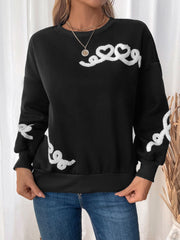 Black crewneck sweatshirt with embroidered white heart detail on sleeve and chest.