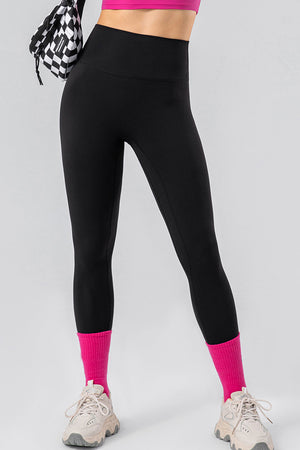 Black high-waist performance leggings with hot pink socks and sneakers
