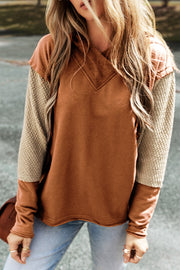 Colorblock hoodie with textured sleeves and V-neck detail in caramel and tan.