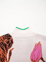 Knit quarter zip sweater with floral pattern and green trim neckline.