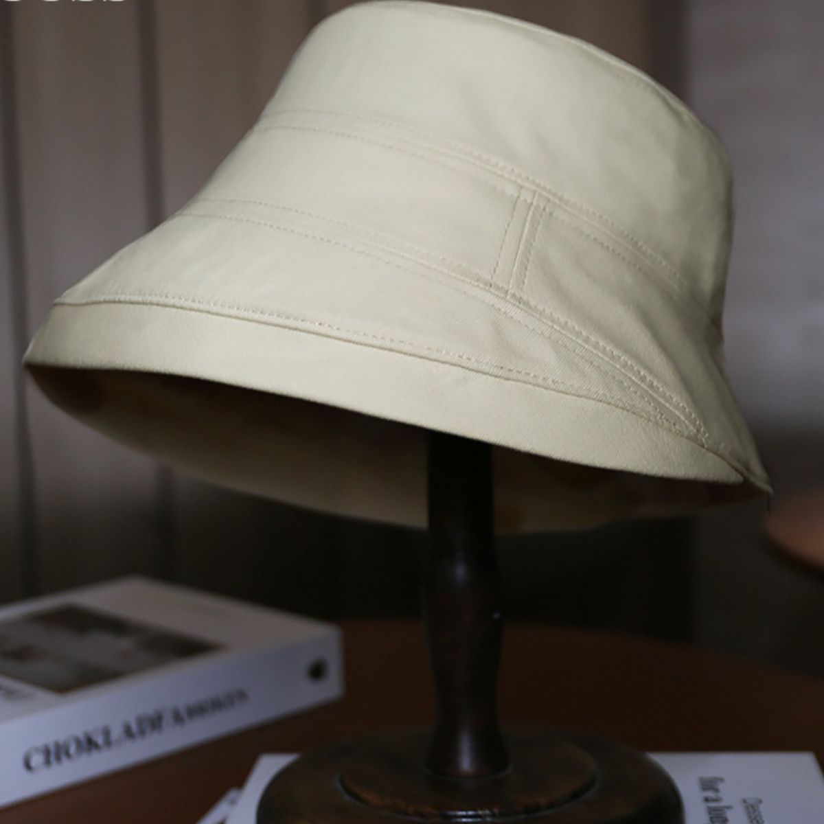 Ivory cotton sun protection bucket hat with stitched details.