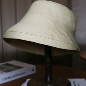 Ivory cotton sun protection bucket hat with stitched details.