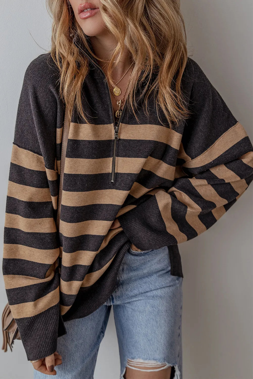 Oversized black and tan striped knit pullover with half-zip neckline and drop shoulders.