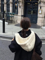 Cozy wool earflap beanie hat in off-white, chunky knit, worn by a person from behind.