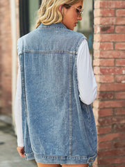 Light wash denim longline vest with collared neckline and utility details, worn over a white long sleeve shirt.