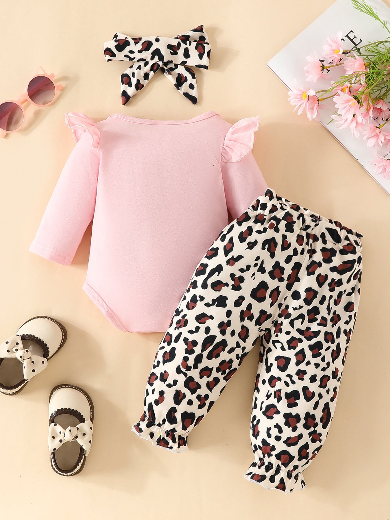 Pink long sleeve bodysuit with ruffled sleeves and leopard print pants with ruffled cuffs.