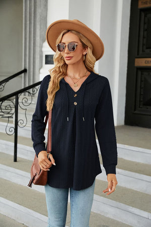Navy textured henley tunic with drawstring hood and button detail.