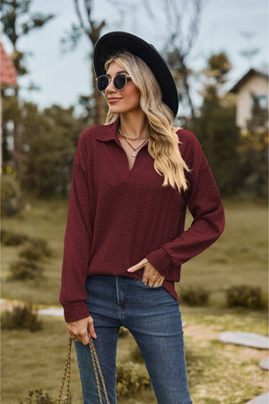 Burgundy textured cable knit polo top with a v-neck and long sleeves.