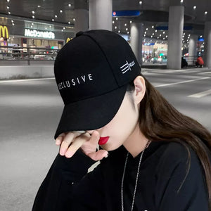 Black cotton baseball cap with white "RECLUSIVE" embroidery and side logo detail.