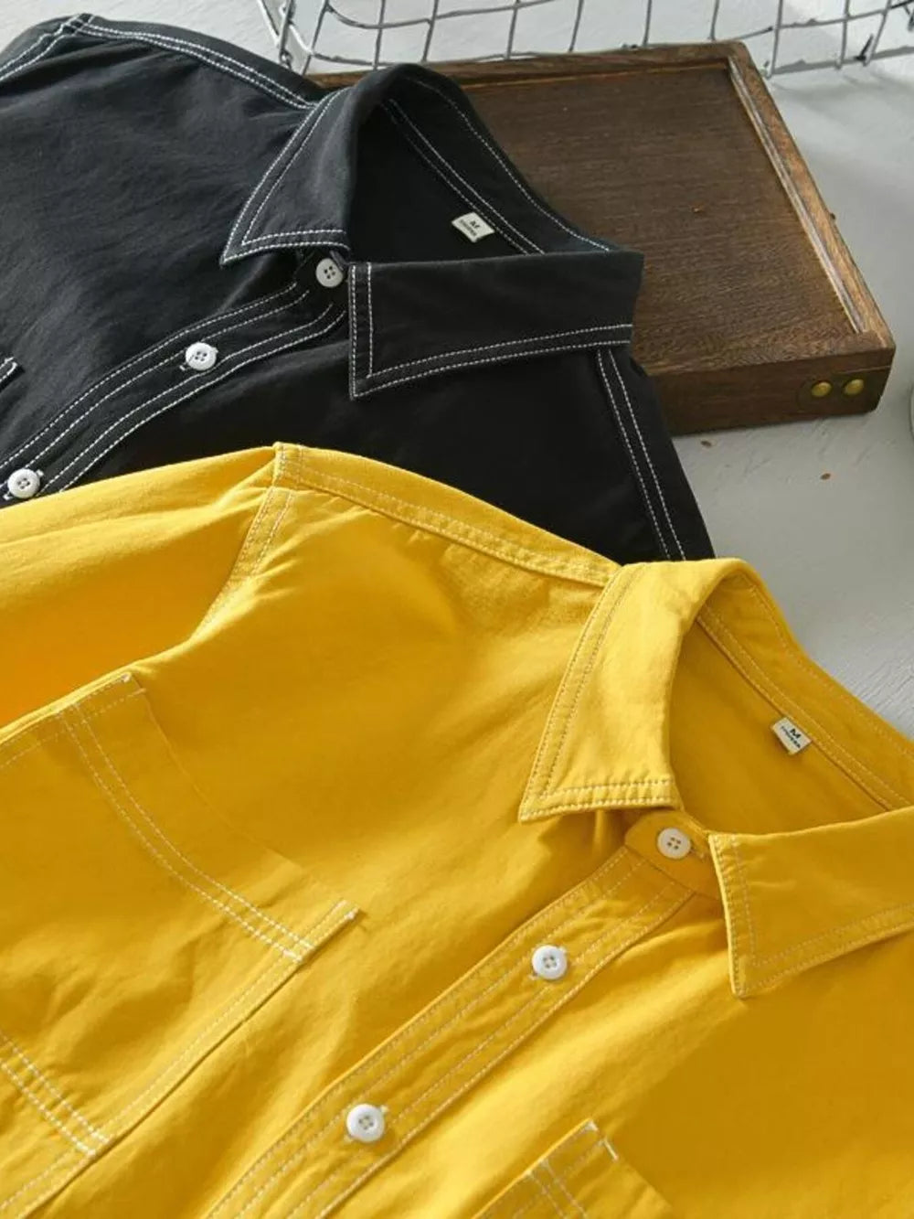 Yellow and black men's button-up shirts with contrast stitching and pockets.