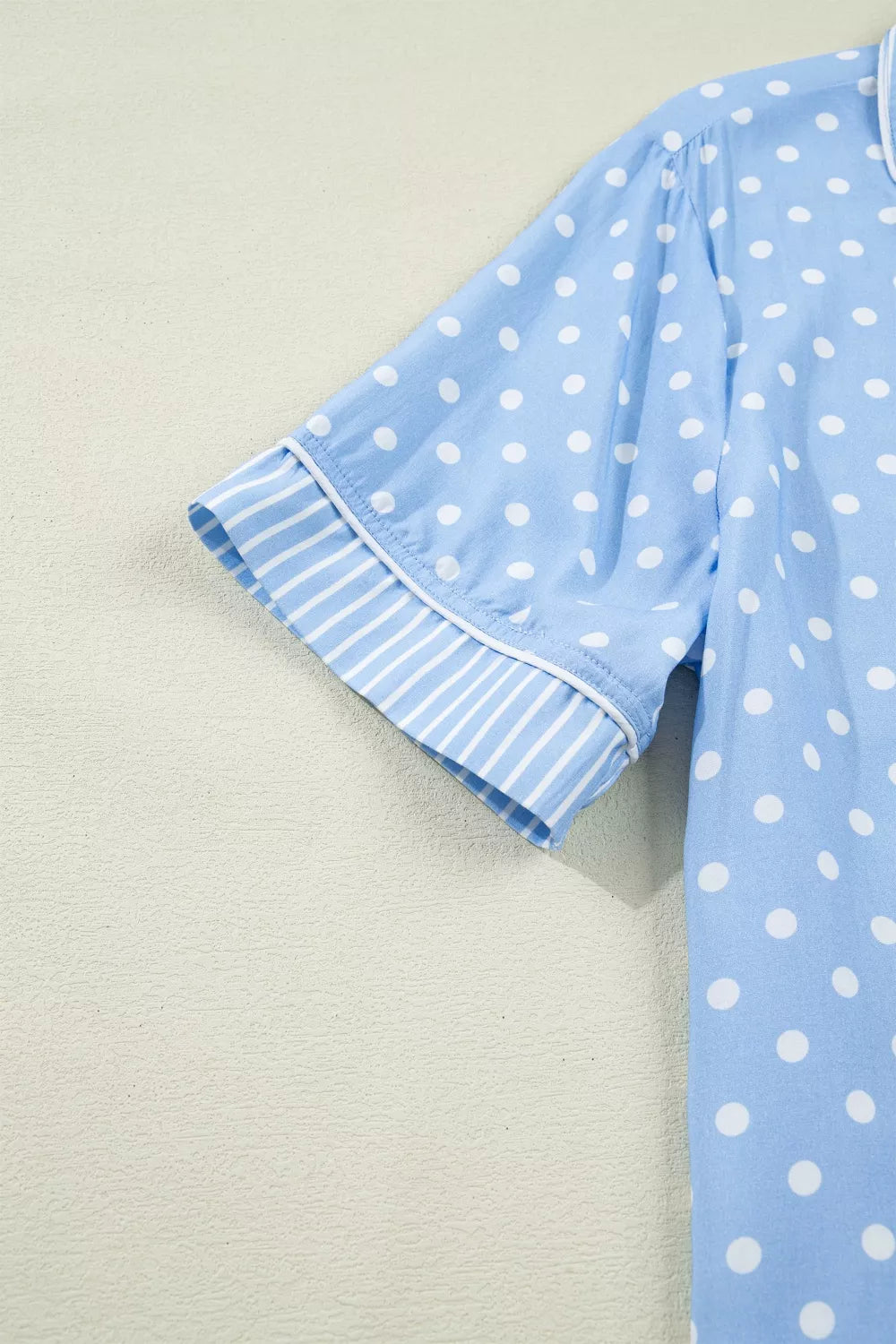 Blue polka dot viscose pajama top with striped cuffs and white piping.