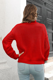 Red acrylic cable knit turtleneck sweater with chevron detail on sleeves.