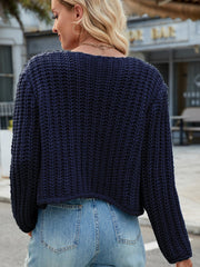 Dark blue chunky knit acrylic cardigan with gold buttons and pockets.