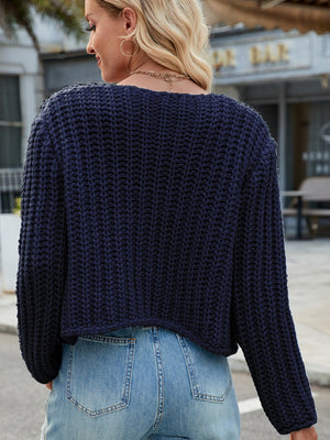 Dark blue chunky knit acrylic cardigan with gold buttons and pockets.
