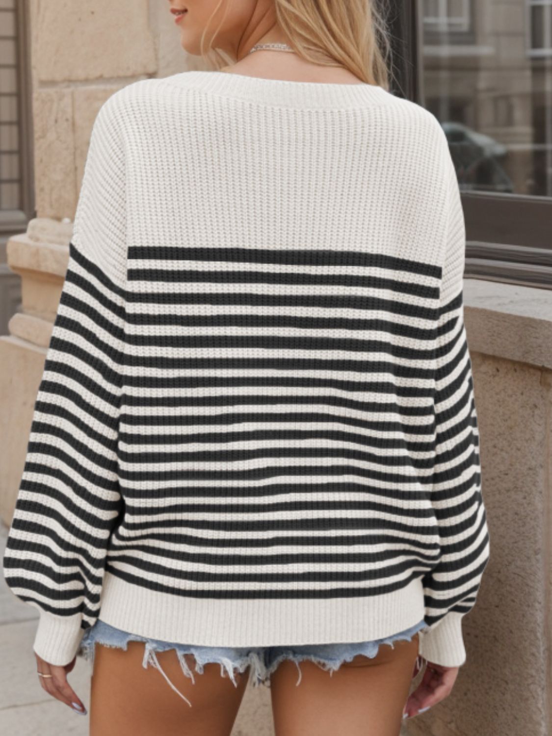 Cream and black striped drop shoulder knit sweater with a crew neck.