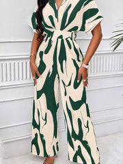 Chic abstract print wide-leg romper in green and cream with short sleeves and a V-neck.