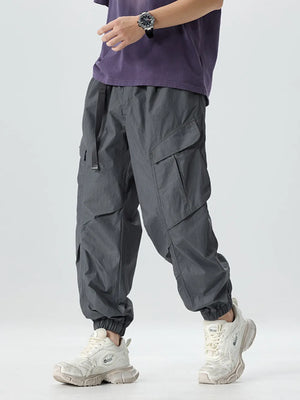 Dark gray oversized cargo pants with adjustable belt and multiple pockets.