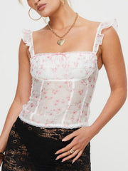 White floral corset cami with lace trim and pink ribbon tie, ruffled straps.