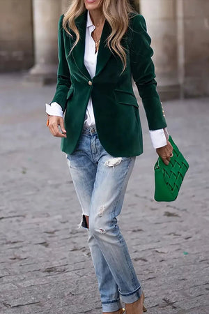 Emerald velvet blazer with gold buttons and flap pockets, styled with a white shirt and distressed jeans.