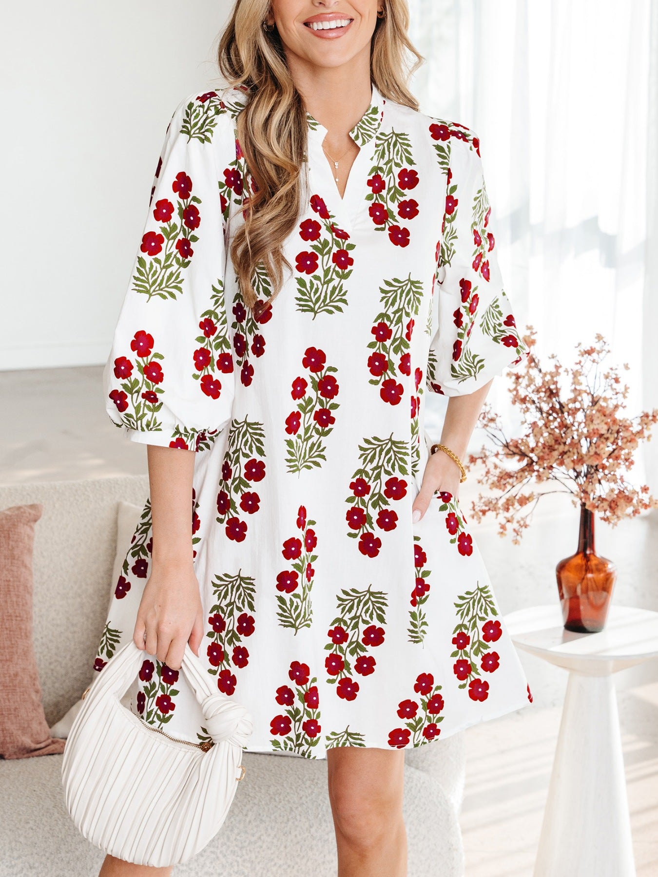 V-neck mini dress with pockets in white with red floral print, cotton fabric, and puff sleeves.