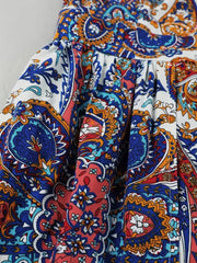 Maternity swim dress with vibrant multicolor paisley print, cinched waist, and dramatic slit detail.