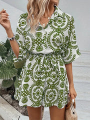 Green printed tie-waist romper with button front and short sleeves.