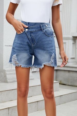 Dusty blue denim shorts with asymmetric waistline and distressed hem
